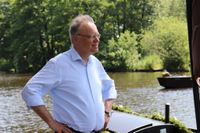 Oben: Acht Torfkähne unter Vollsegel auf dem Weg zu „Melchers Hütte“. Links: Der Ministerpräsident blickt stolz auf die Hamme.