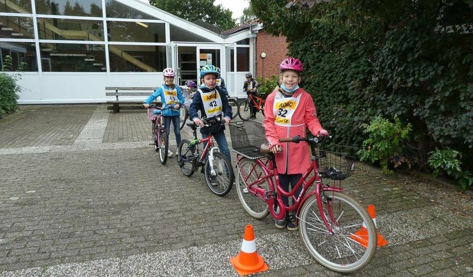 Die Grundschüler:innen warten aufgeregt auf den Beginn der Fahrradprüfung.