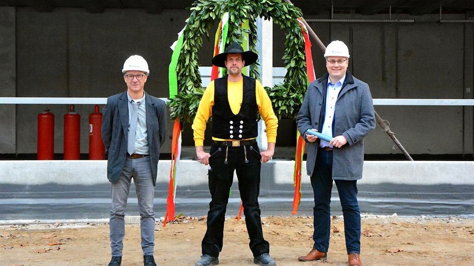 Schulleiter Dr. Uwe Strohbach (v. li.), Zimmermann Max Holtkamp und Landrat Marco Prietz beim Richtfest.