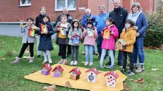 Gemeinsam mit Antje Kappel, Detlev Frank, Werner Pommer, Karl-Heinz Kabbeck, Heinz Freese und Christine Struthoff präsentieren die kleinen Baufrauen und -herren der „Rainbow Kids“ stolz die neuen „Vogeleigenheime“.