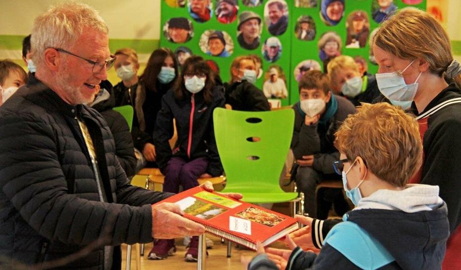 Jürgen Röper vom NABU Hambergen übergab das Moorbuch und damit die Patenschaft für das Heilsmoor an Kathleen Pallaske und Enno Funk aus dem siebten Jahrgang der KGS.