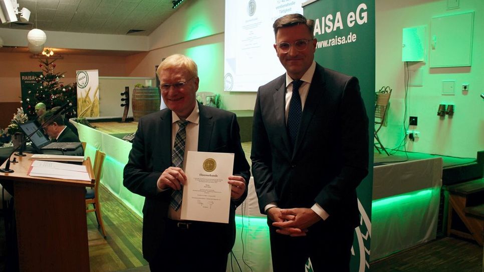 Verleihung der Ehrennadel in Gold für 40 Jahre Tätigkeit im Genossenschaftswesen an Axel Lohse, links. rechts Peter Götz, Genossenschaftsverband