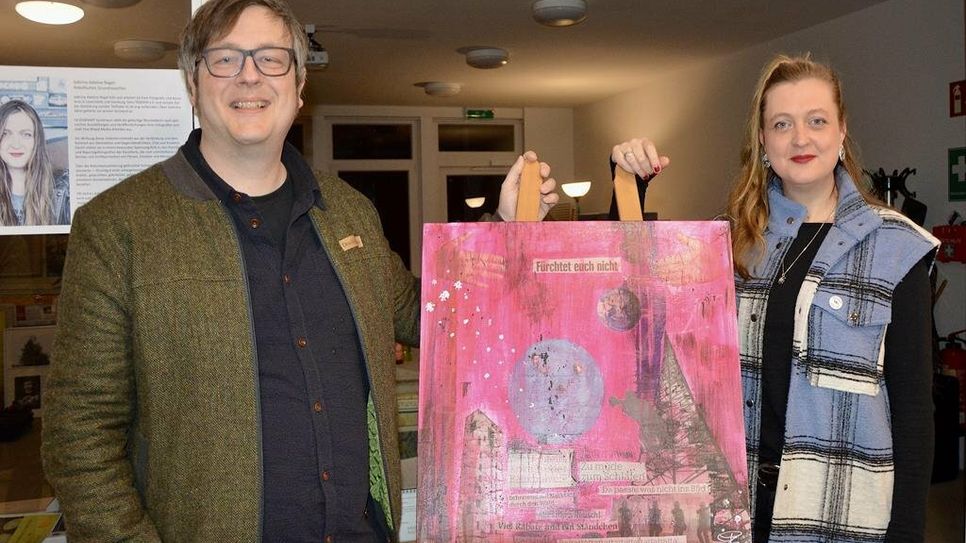 Ehemann und Kurator Christoph Nagel mit Künstlerin Sabrina Adeline Nagel vor einem Bild, das nach Beendigung der Ausstellung im Büro des Bürgermeisters einen Platz finden könnte.