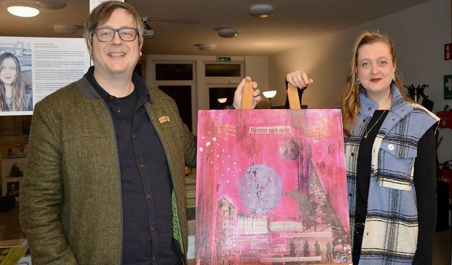 Ehemann und Kurator Christoph Nagel mit Künstlerin Sabrina Adeline Nagel vor einem Bild, das nach Beendigung der Ausstellung im Büro des Bürgermeisters einen Platz finden könnte.
