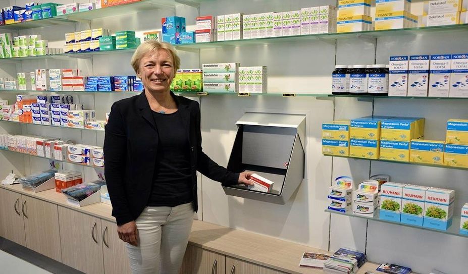 Sigrid Kölling zeigt den Kommissionierer, mit dem Medikamente schnell nach vorne in den Verkaufsraum befördert werden können.