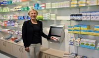Sigrid Kölling zeigt den Kommissionierer, mit dem Medikamente schnell nach vorne in den Verkaufsraum befördert werden können.