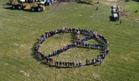 Über 200 Menschen bildeten zum Abschluss der Aktion "Kinder helfen" auf einer Weide in Scharmbeckstotel das Friedenszeichen.