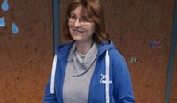 Bettina Schroeder freut sich über die gelungene bauliche Umsetzung und fügt das geeignete Nistmaterial hinzu.