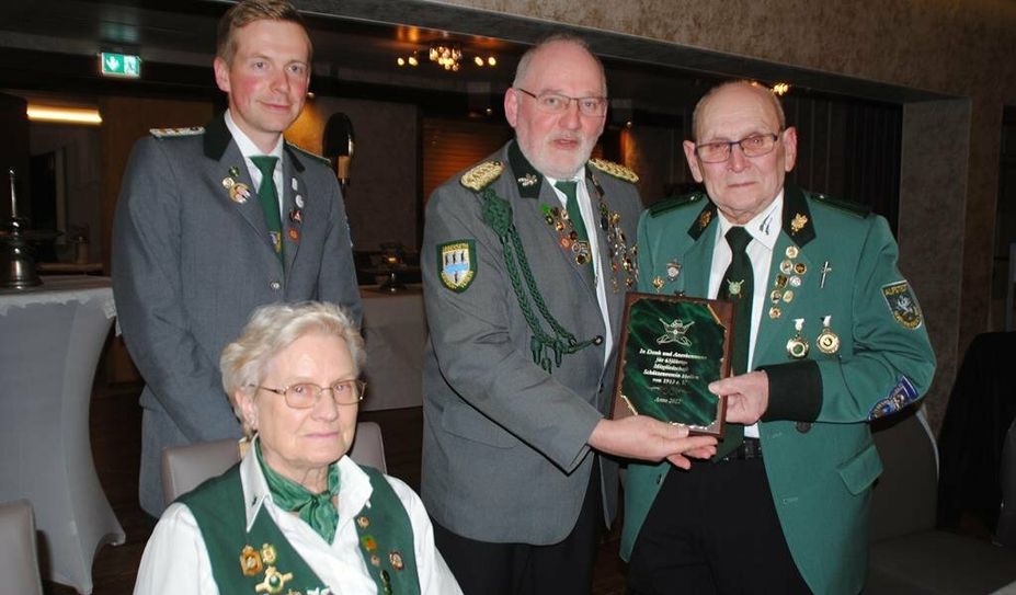 Tobias Wehber und Heino Siems überreichen dem sichtlich gerührten Reinhard Quast und seiner Frau Karin eine Plakette für 65 Jahre Mitgliedschaft im Verein.