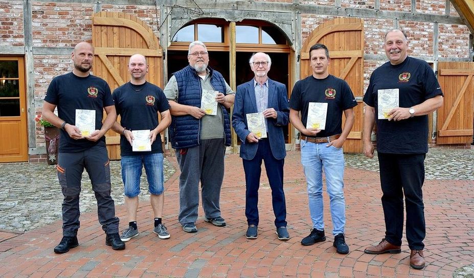 Thomas Lindner (v. li.), Jens Meyer, Gerhard Burfeindt, Hans Wilhelm Peper, Sebastian Fischer und Ortsbürgermeister Andreas Itzen präsentieren vor dem Logehuus  die druckfrischen Exemplare der Festschrift.