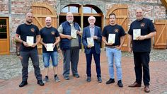 Thomas Lindner (v. li.), Jens Meyer, Gerhard Burfeindt, Hans Wilhelm Peper, Sebastian Fischer und Ortsbürgermeister Andreas Itzen präsentieren vor dem Logehuus  die druckfrischen Exemplare der Festschrift.