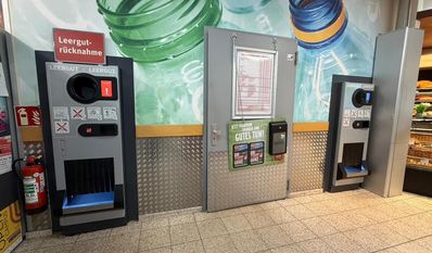 Die Spendenbox für die Pfandbons hängt genau zwischen den Leergutautomaten.