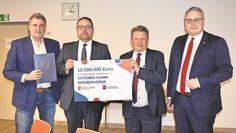 Dr. Andreas Philippi (2. v. l.) und Marco Prietz (rechts) präsentieren den symbolischen Scheck.