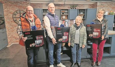 Rechtzeitig zur bevorstehenden Weihnachts-Bäckerei durften sich Jens Schloßstein, Ute Hartje und Susanne Schlüter über eine leuchtend rote Küchenmaschine von AEG freuen. Küchenstudio-Hausleiter Söhnke Bohlen (2. v.l.) half gern beim Tragen. Foto: cne
