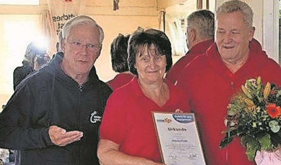 Jürgen Linke vom KSB überreicht der Übungsleiterin Iris Flömer die Urkunde und das Überraschungspaket.