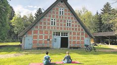 Beim Yoga auf dem historischen Gelände des Moorhofs können sich die Gäste entspannen.