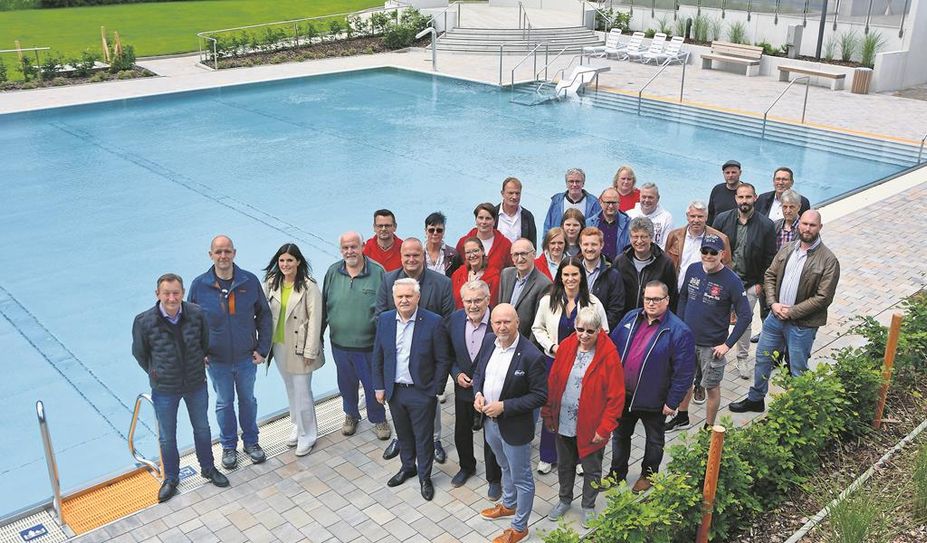 Wimmelbild mit zahlreichen Delphino-Mitarbeitenden sowie am Umbau des neu sanierten Freibades beteiligten verantwortlichen Personen