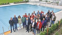 Wimmelbild mit zahlreichen Delphino-Mitarbeitenden sowie am Umbau des neu sanierten Freibades beteiligten verantwortlichen Personen