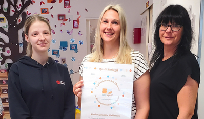 Einrichtungsleiterin Anneke Fischer (Mitte) freut sich mit ihren zwei Mitarbeiterinnen über das Siegel.