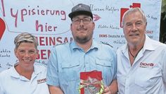 Katja Hösseibarth (links) und Gerd Holzhauer (rechts) von der DKMS freuen sich über ihren 100. Spender Dominik Abdalla.