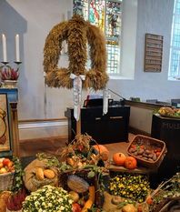 Die Erntekrone wird über den Erntegaben aufgehängt.