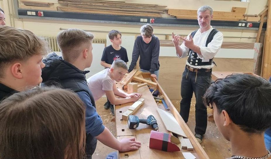 Wie geht es jetzt weiter mit dem Zimmererbock? Fachlehrer Johannes Overesch erklärt den Schülern die nächsten Arbeitsschritte. Foto: cne