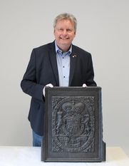 Frank Pingel stellt eine Ofenplatte mit dem Wappen von König Georg II. vor.