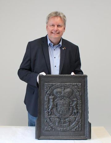 Frank Pingel stellt eine Ofenplatte mit dem Wappen von König Georg II. vor.
