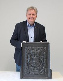 Frank Pingel stellt eine Ofenplatte mit dem Wappen von König Georg II. vor.