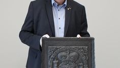 Frank Pingel stellt eine Ofenplatte mit dem Wappen von König Georg II. vor.
