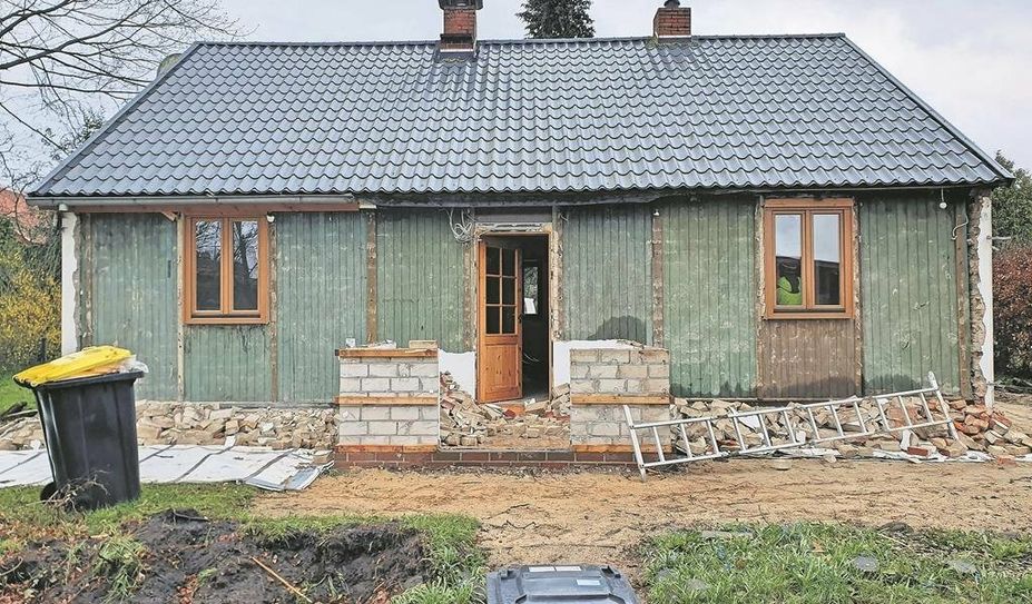 Ansicht des Häuschens, nachdem das Verblendmauerwerk entfernt wurde. Deutlich ist die grün gestrichenen Wehrmachtsbaracke erkennbar.