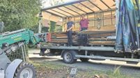 Ines Dirolf und Andreas Ehresmann nehmen auf einem LKW die Paletten mit den Wandelementen an