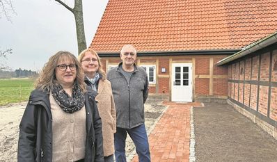 Debbie Bülau zeigt ein Album mit alten Fotos, Andrea Dankert ein altes Dokument, das auch noch eingescannt werden muss.