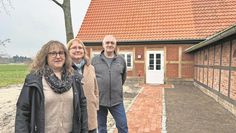 Debbie Bülau zeigt ein Album mit alten Fotos, Andrea Dankert ein altes Dokument, das auch noch eingescannt werden muss.