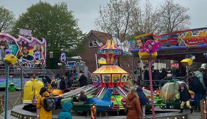 Viele bunte Fahrgeschäfte warten auf die Besucher:innen des Herbstmarktes.