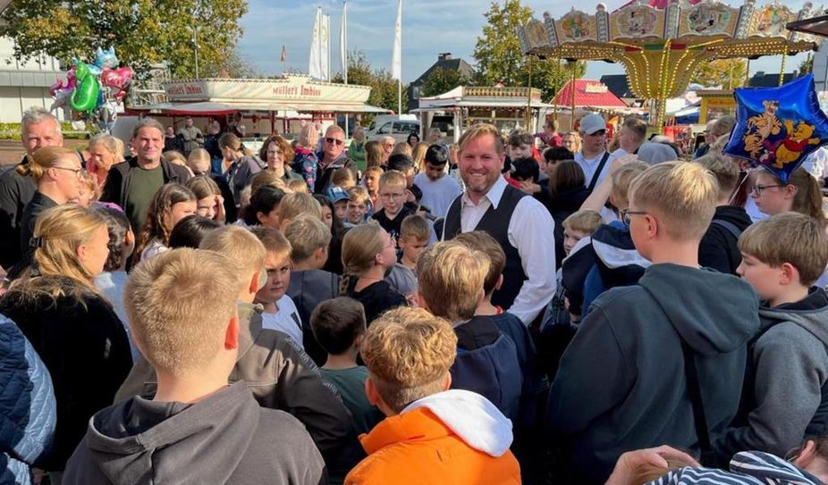 Bürgermeister Marc Breitenfeld verteilt Fahrchips an Kinder und Jugendliche.