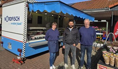 Seit Ende September steht Ines Osterloh (li.) mit Ehemann Karsten (re.) jeden Mittwoch von 9 bis 16 Uhr auf dem Parkplatz vor dem Vollsortimenter. nahkauf-Geschäftsführer Hakan Özgüc (Mitte) freut sich, das Angebot für seine Kunden vervollständigt zu haben.