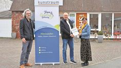 Andreas von Glahn (li.) mit Thomas Stutz, der die Urkunde an Anja Schlesselmann-Jansen überreichte.