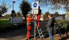 Bürgermeister Kim Fürwentsches (rechts) begutachtet das neue Schild, das von Mitarbeitenden des Baubetriebshofs aufgestellt wurde.