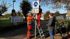 Bürgermeister Kim Fürwentsches (rechts) begutachtet das neue Schild, das von Mitarbeitenden des Baubetriebshofs aufgestellt wurde.