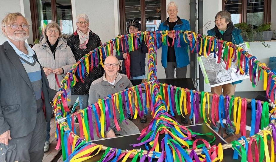 Mitglieder:innen des Friedensbündnis mit ihrem gebastelten Peace-Zeichen gegen den Krieg.