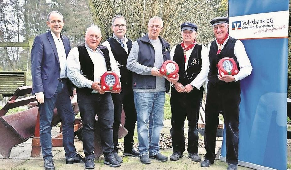 Jan Mackenberg (links) freut sich, die drei „Defis“ überreichen zu können.