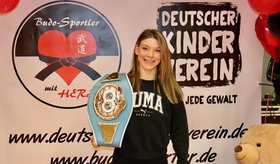 Strahlen um die Wette: Kampagnen-Botschafterin Nina Meinke und ihr Weltmeistergürtel.