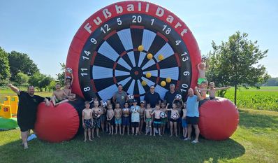 Die Kinder und Trainer freuen sicht sichtlich über die Spende der Fußbälle.