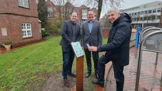 Bürgermeister Torsten Rohde (rechts) macht es vor: Einfach mit dem Smartphone den QR-Code wie hier am Schlauchturm scannen und dann der Geschichte der ehemaligen Feuerwache lauschen. Foto: cne