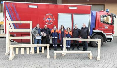 Andreas Brünjes übergibt die neuen Hindernisse an Mitglieder und Betreuer der Jugendfeuerwehr.