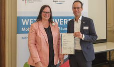Dezernent Dominik Vinbruck übernahm die Auszeichnung von Melanie Schade, Leiterin des PG Kompetenzzentrum für Ländliche Mobilität, entgegen.