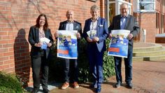 Mareike Wilshusen (v. li.), Bürgermeister Michael Hannebacher, Marco Tulodetzki und Manfred Mühler präsentieren die Plakate und Flyer, mit denen ab sofort Kandidatinnen für den Wirtschaftspreis vorgeschlagen werden können.