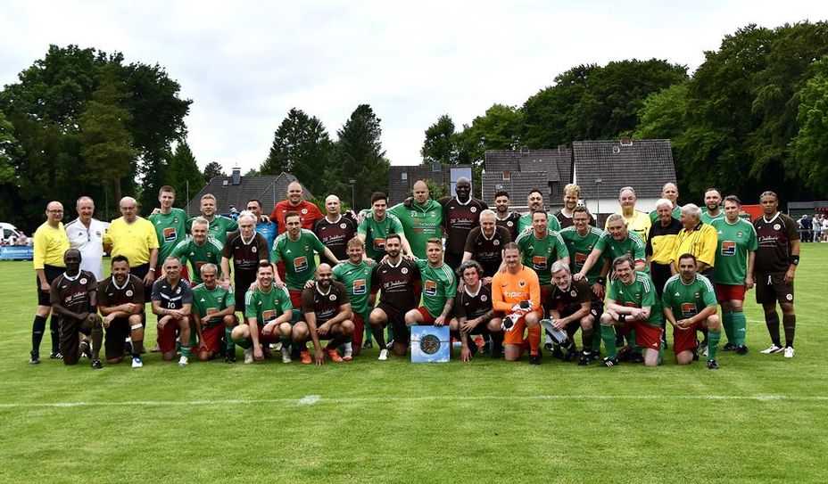 Die Traditionsmannschaften vor dem Spiel mit dem BSC-Vorsitzendem Udo Engelke (stehend 2.v.l.) und dem Präsent des Ortsrates (Bildmitte, blau).