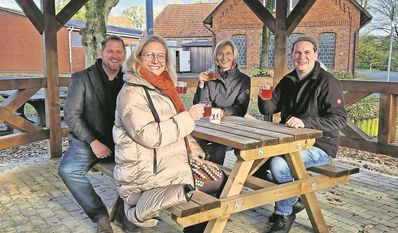 Die Mitwirkenden aus der Gemeinde und Ulrike Schloen vom Inner Wheel Club Nordheide (vorne links) probieren die neue Sitzgelegenheit direkt aus.